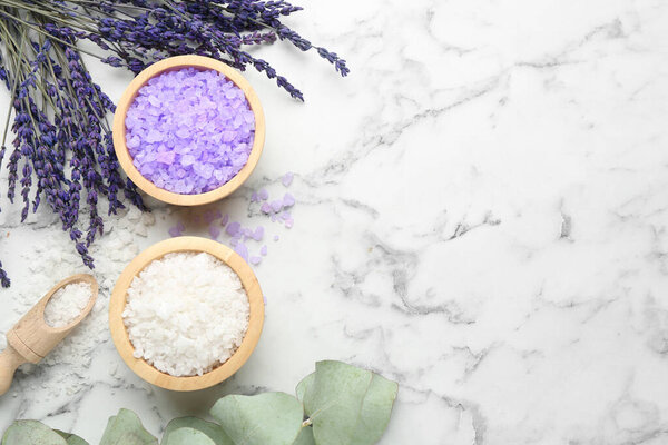 Sea salt, lavender and eucalyptus leaves on white marble table, flat lay. Space for text