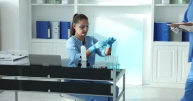 Genetik araştırması. Laboratuvarda numunelerle çalışan bilim adamları, kamera yükseliyor.