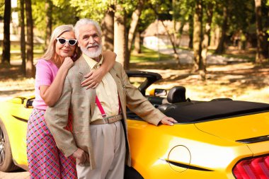 Modern Cabriolet yakınlarında şık bir yaşlı çift.