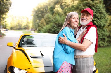 Modern Cabriolet yakınlarında şık bir yaşlı çift.