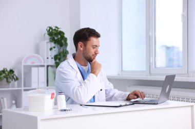 Hastanede dizüstü bilgisayarda çalışan bir çocuk doktoru.