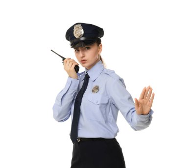 Beyaz arka planda telsizi olan üniformalı genç bir kadın polis.