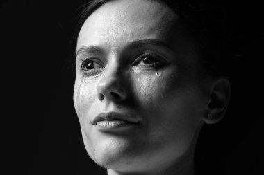 Üzgün kadın karanlık arka planda ağlıyor, yakın planda. Siyah ve beyaz etkisi