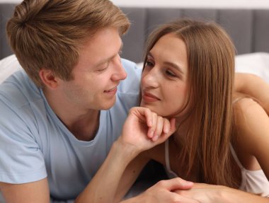 Evdeki yatakta eğlenen sevimli çift.