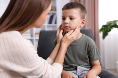 Anne üzgün oğlunu evde destekliyor, yakın plan.