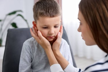 Anne üzgün oğlunu evde destekliyor, yakın plan.