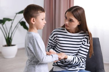 Annesi evde üzgün oğluyla el ele tutuşmuş.