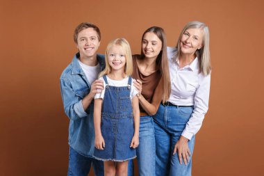 Kahverengi arka planda oğlu ve ailesi olan yaşlı bir kadının portresi.