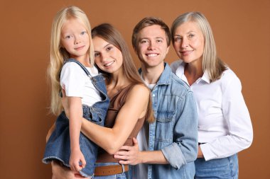 Kahverengi arka planda oğlu ve ailesi olan yaşlı bir kadının portresi.