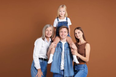 Kahverengi arka planda oğlu ve ailesi olan yaşlı bir kadının portresi.