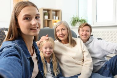 Mutlu kadın evde ailesiyle selfie çekiyor.