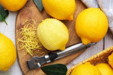 Limon lezzeti, taze meyve, zester aracı ve yeşil yapraklar masada, düz yatıyordu.