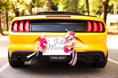 Düğün arabası. Cabriolet dekore edilmiş. Sadece evlilik kartı ve açık havada güzel çiçekler, yakın plan.