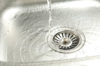 Water going down sink drain, closeup view
