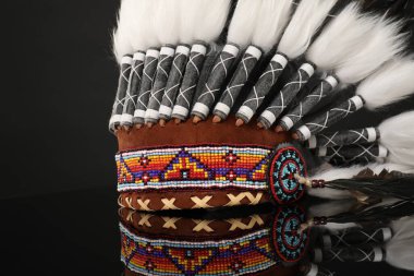 Geleneksel warbonnet (Yerli Amerikan baş başlığı) siyah ayna yüzeyinde, yakın plan