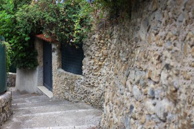 Güzel taş çitlerin yanında merdivenleri olan yol.