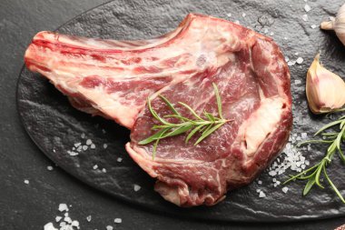 Siyah masada çiğ et ve baharat var.