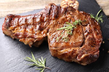 Ahşap masada otlu leziz biftek, yakın plan.