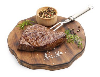 Delicious grilled beef steak with herbs, spices and carving fork isolated on white