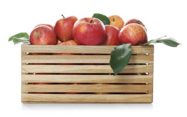 Tahta sandıktaki taze elmalar ve beyaz üzerine izole edilmiş yeşil yapraklar.