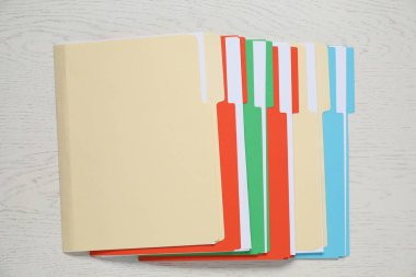 Beyaz ahşap masadaki dizinlerde birçok belge, üst görünüm