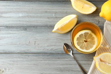 Bardakta romatik çay, tahta masada limon ve kaşık, düz yatak. Metin için boşluk