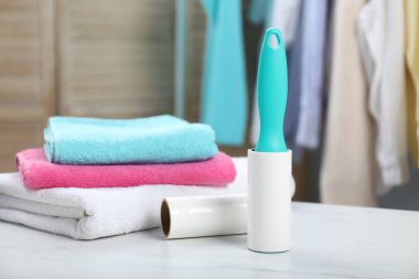 Lint rulo, yapışkan rulo ve beyaz mermer masa içinde havlu yığını