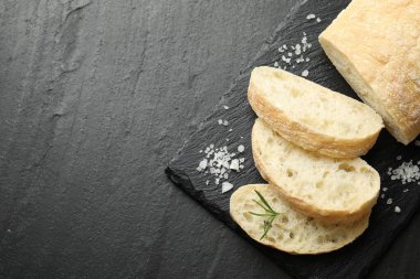Çıtır ciabatta, biberiye ve tuz, siyah desenli masa, üst manzara. Metin için boşluk