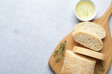 Taze çıtır ciabatta, yağ ve bitkiler gri masada, düz yerde. Metin için boşluk