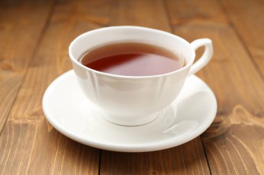 Ahşap masada bir fincan siyah çay, yakın plan.