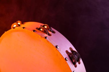 Tef, koyu arkaplanda renkli ışık ve dumanla yakın plan.