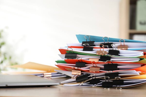 Many folders with documents and binder clips on wooden desk, closeup. Space for text