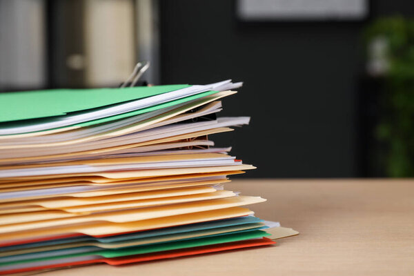 Много папок с документами на деревянном столе, крупным планом. Пространство для текста