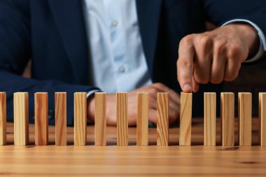 Risk. Masasında tahta bloklar olan adam, yakın plan.