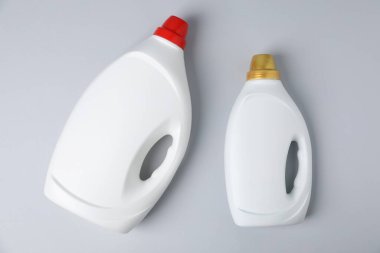 Bottles of fabric softener on light grey background, flat lay
