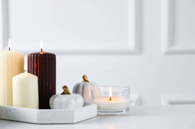 Beyaz masada birçok farklı yanan mum, yakın plan. Metin için boşluk