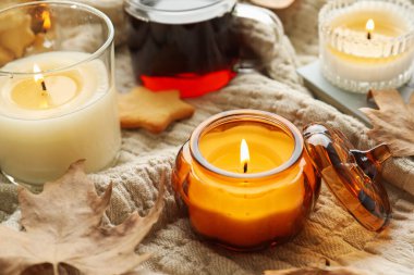 Yakıcı mumlar ve ekoseli çay, yakın plan. Sonbahar atmosferi