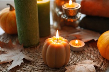 Masada mumlar ve kuru yapraklar yanıyor, yakın plan. Sonbahar atmosferi