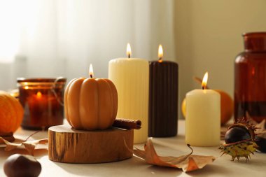 Farklı yanan mumlar ve sonbahar dekoru Beyaz masa kapalı, yakın çekim