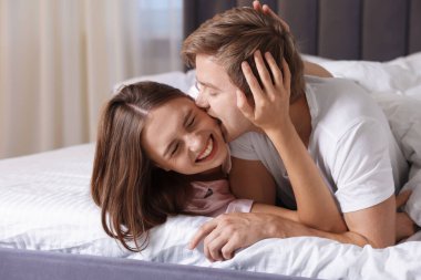 Evdeki yatakta eğlenen sevimli çift.