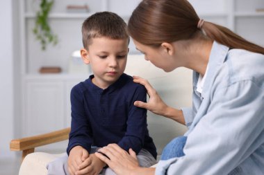 Anne, üzgün oğlunu evde destekliyor.