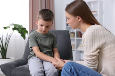 Annesi evde üzgün oğluyla el ele tutuşmuş.