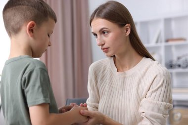 Anne, üzgün oğlunu evde destekliyor.