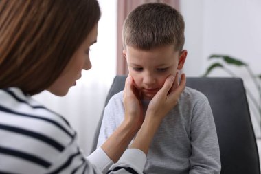 Anne üzgün oğlunu evde destekliyor, yakın plan.