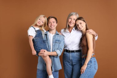 Kahverengi arka planda oğlu ve ailesi olan yaşlı bir kadının portresi.