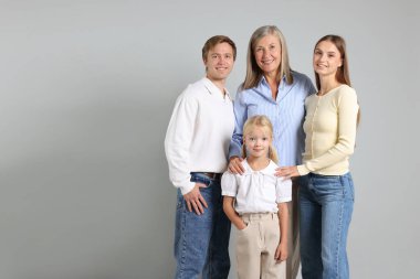 Aydınlık bir arkaplanda son sınıf öğrencisi ve ailesinin portresi. Metin için boşluk