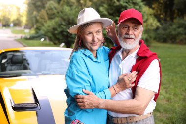 Modern Cabriolet yakınlarında şık bir yaşlı çift.