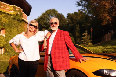 Modern Cabriolet yakınlarında güneş gözlüklü şık bir çift.