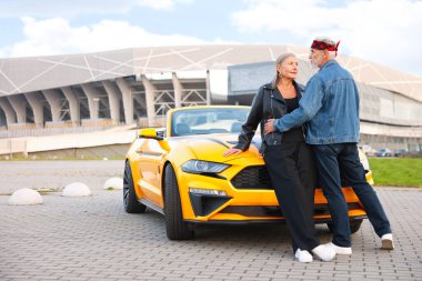 Modern Cabriolet yakınlarında şık bir yaşlı çift.