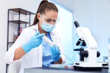 Genetik araştırması. Laboratuvarda çalışan mikro pipet ve mikro plakalı bir bilim adamı.